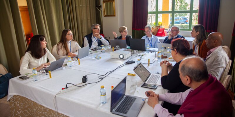 working group of people around table with laptops